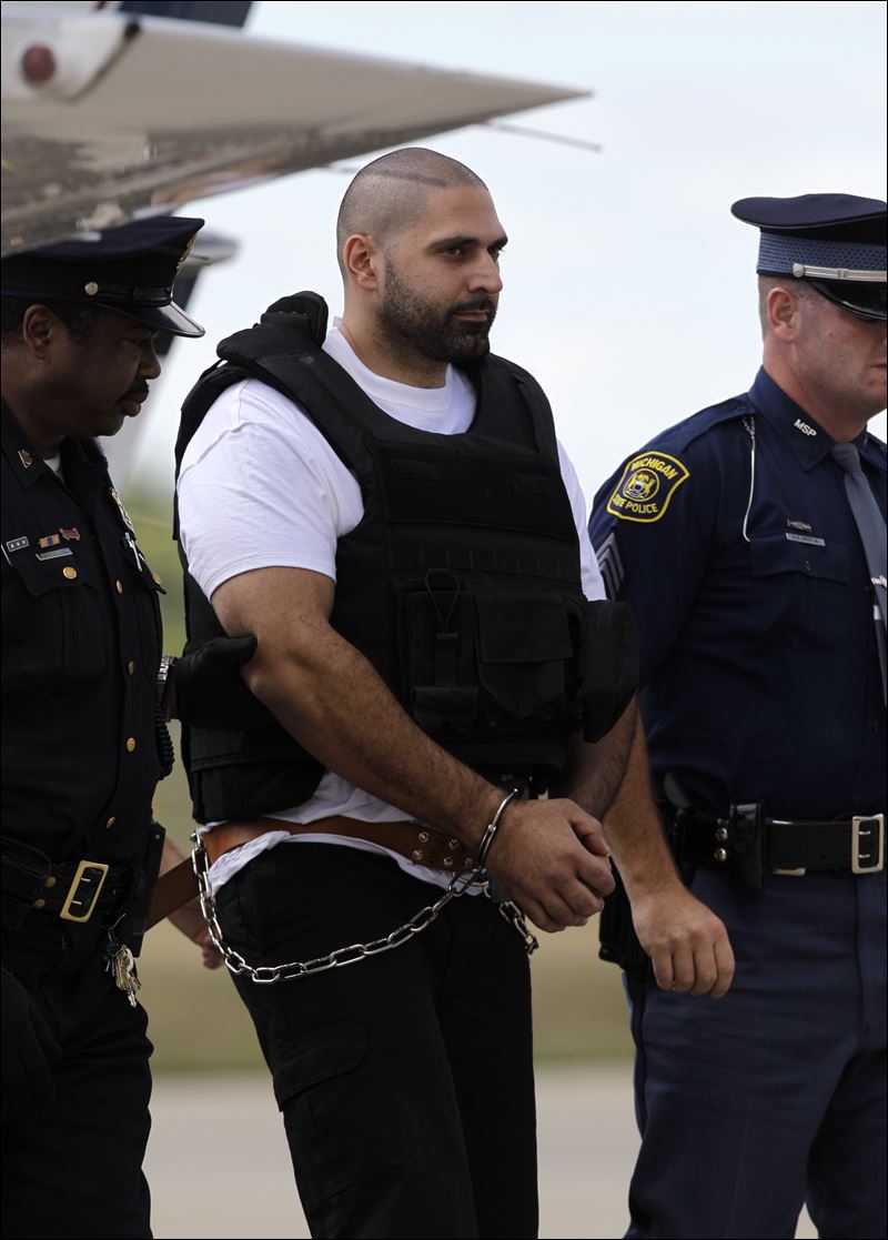Na foto: O serial killer Elias Abuelazam chegando em Michigan escoltado por mais de dez policiais. Créditos: PAUL SANCYA / AP