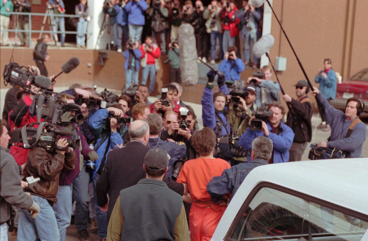 Uma multidão de repórteres espera a chegada de um dos mais notórios criminosos da história americana. O "Unabomber", de uniforme laranja, caminha escoltado até uma corte federal em Helena, Montana, em 4 de Abril de 1996, dia em que foi preso. Elaine Thompson | AP Photo.