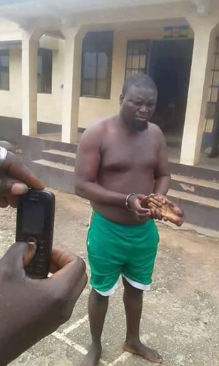 Um dos canibais é fotografado segurando uma mão decepada. Foto: Uganda News.