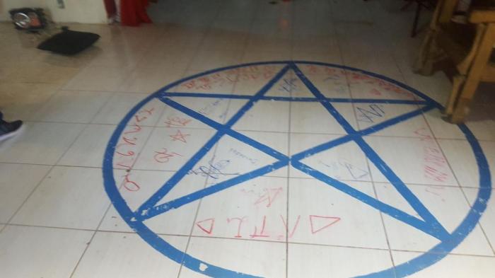No chão do templo há um pentagrama desenhado com escritos em vermelho, possivelmente sangue. Foto: Polícia Civil RS.